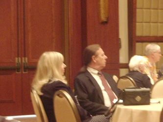 Suzanne Mitchell and Charlie Glaser sitting at a table during a meeting